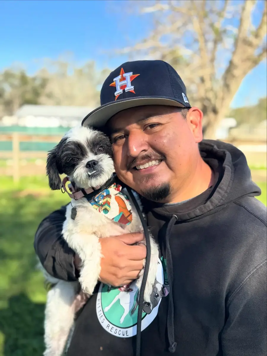 Armando, Lead Dog Trainer, holding a rescue dog